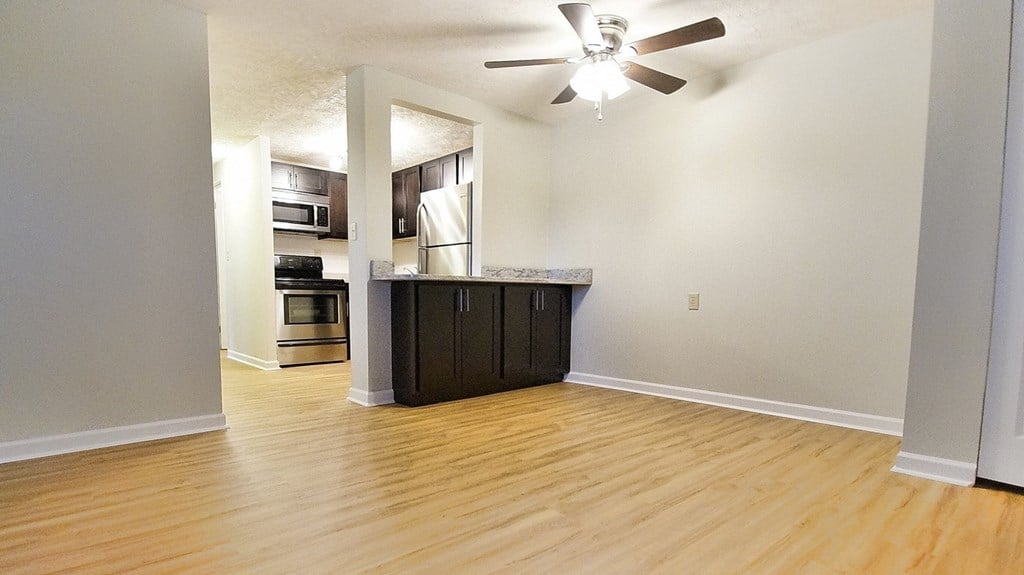 A room with a ceiling fan and wooden flooring.