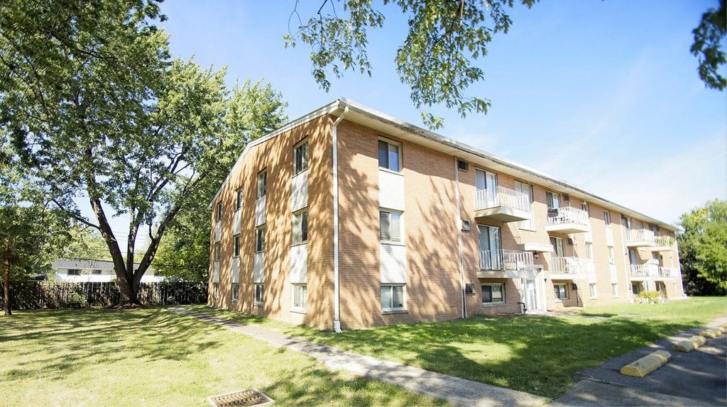 A large apartment building with a tree in front of it.