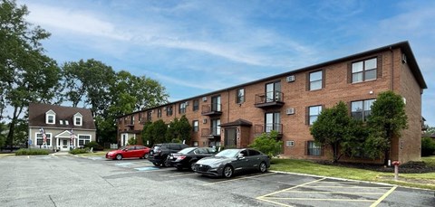 a parking lot in front of a brick apartment building