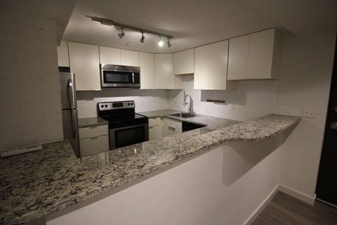 A kitchen with granite countertops and stainless steel appliances.