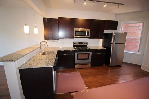 A kitchen with a granite counter top and stainless steel appliances.