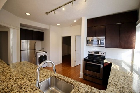A kitchen with granite countertops and stainless steel appliances.