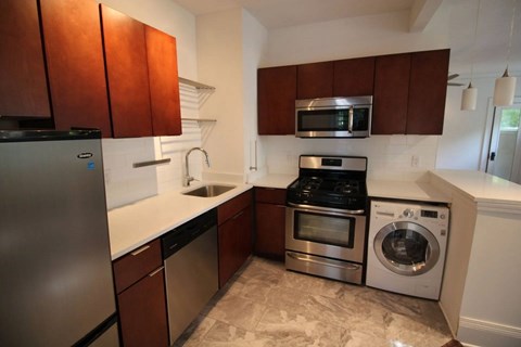 A kitchen with brown cabinets and stainless steel appliances.