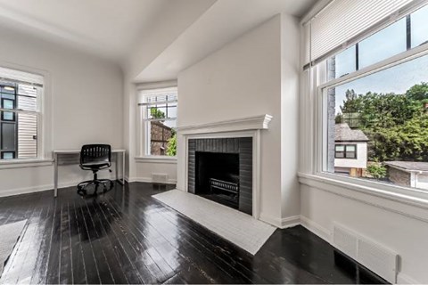 Bright living room with fireplace and dark hardwood floors at Reserve Overlook* Apartments, Ohio