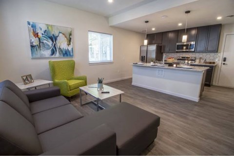 A modern living room with a grey sofa and a green armchair.