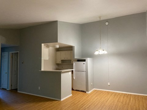 A kitchen with a refrigerator, microwave, and oven.