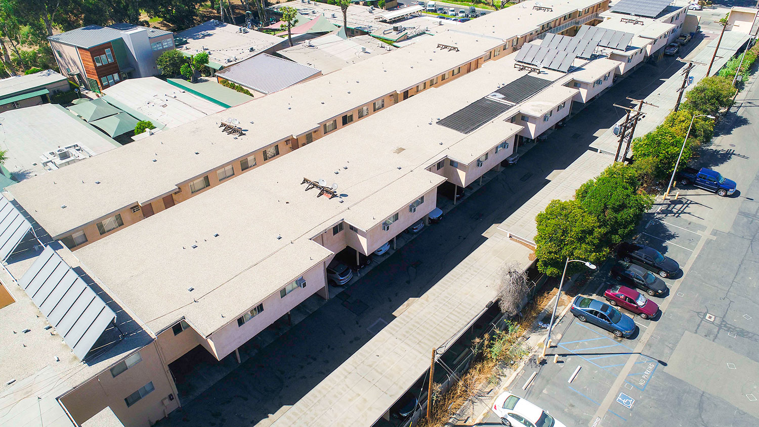 Aerial drone photo of Woodbridge Park Apartments, showing white solar roofs and Solar Panels.