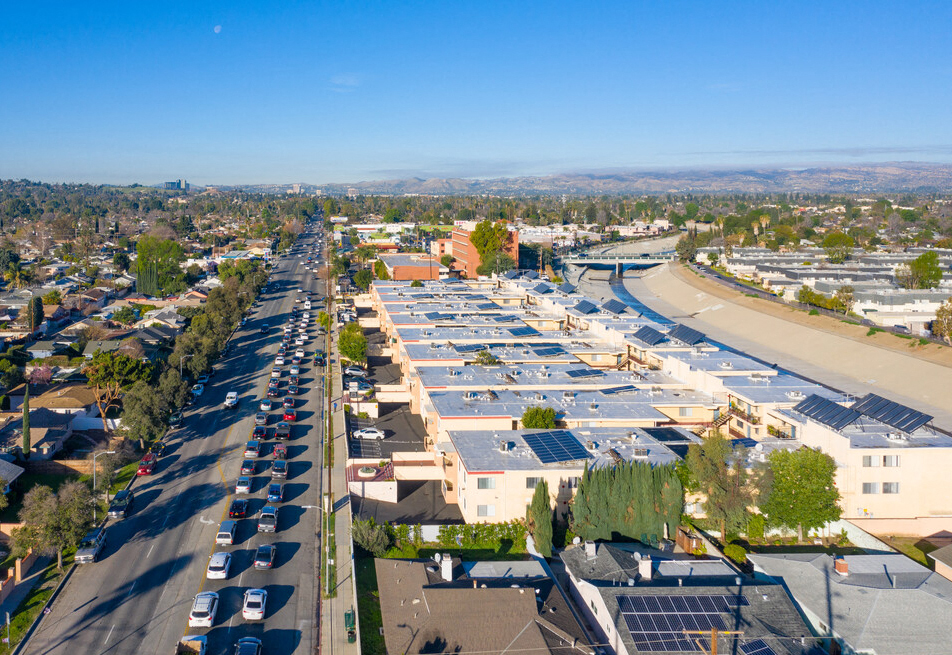 Aerial drone photo of Riverbridge Apartments showing solar panels and energy-efficient white roofs.