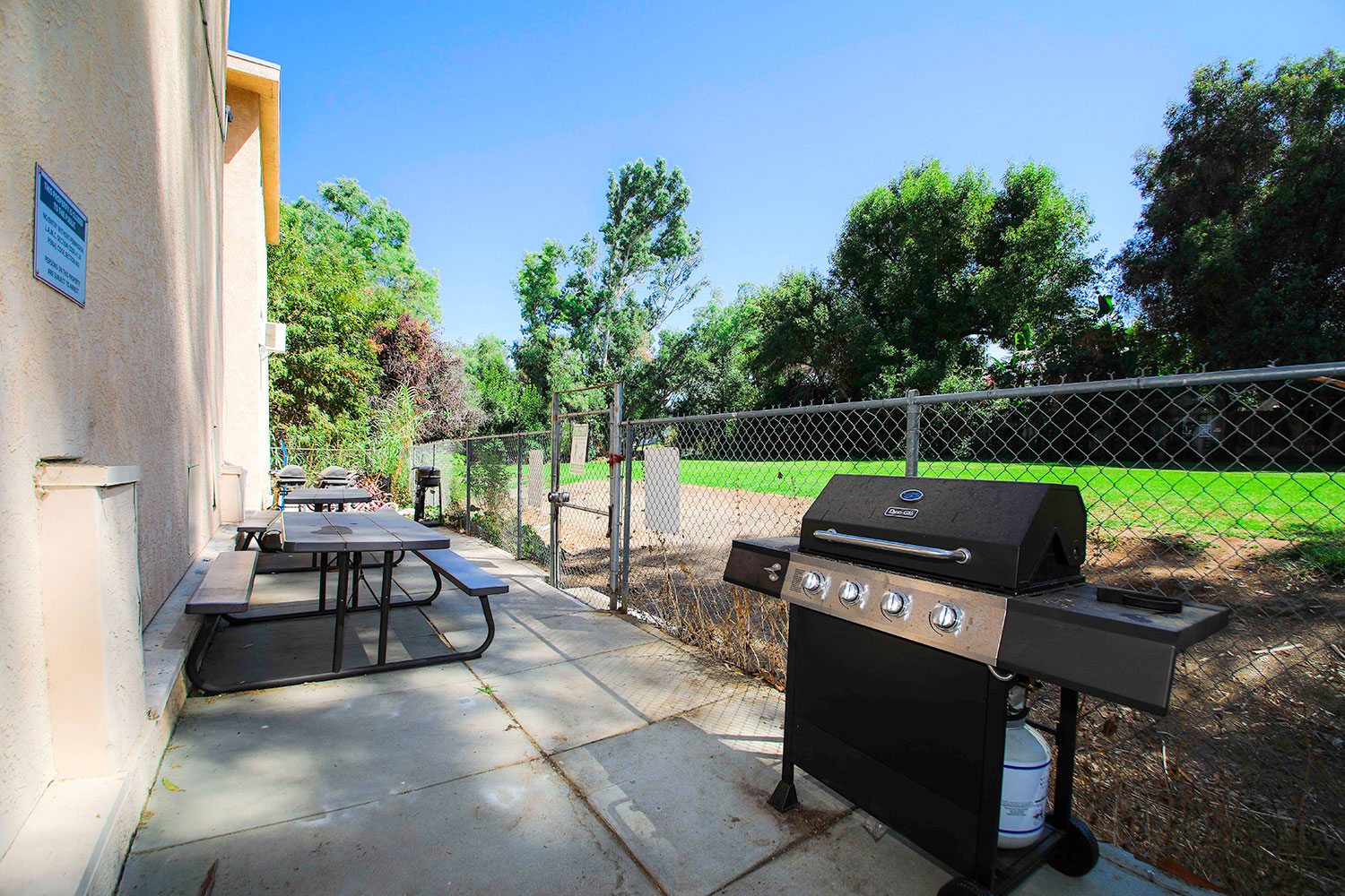 Outdoor barbeque space adjacent and connected to neighboring park space.