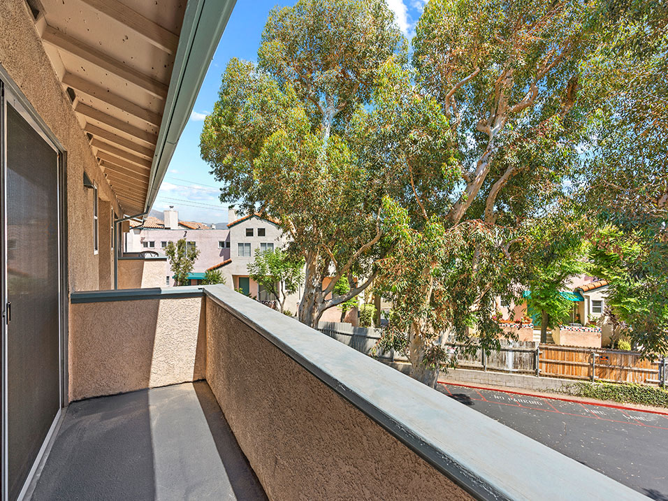 Private balcony with view of tree lined surrounding community.