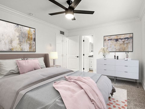 Carpeted bedroom with ceiling fan and access to private bathroom.