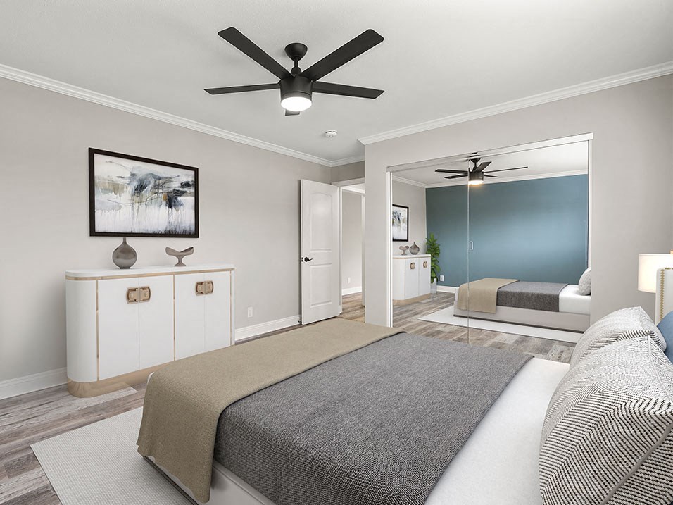 Carpeted bedroom with ceiling fan.