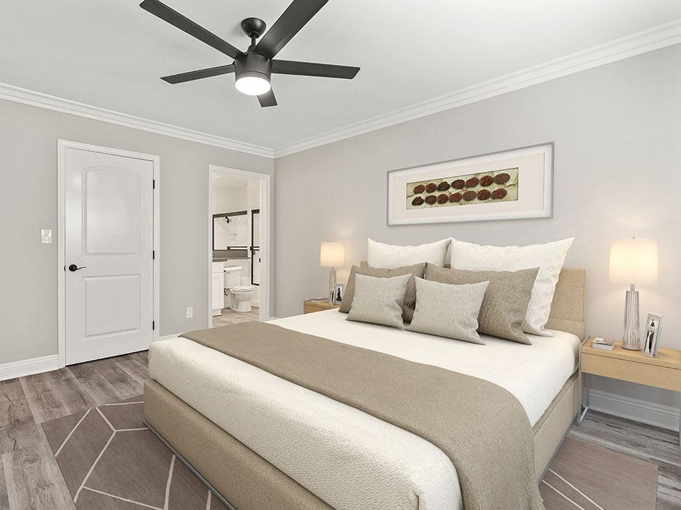 Carpeted bedroom with large mirrored closet and ceiling fan.