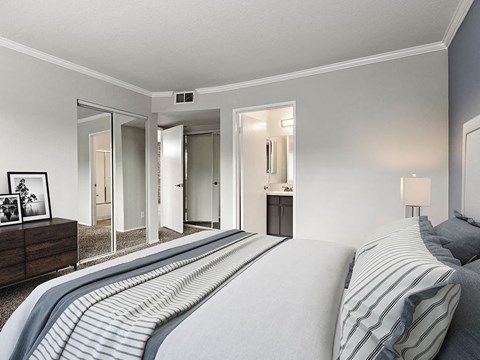 Carpeted bedroom with access to private bathroom.