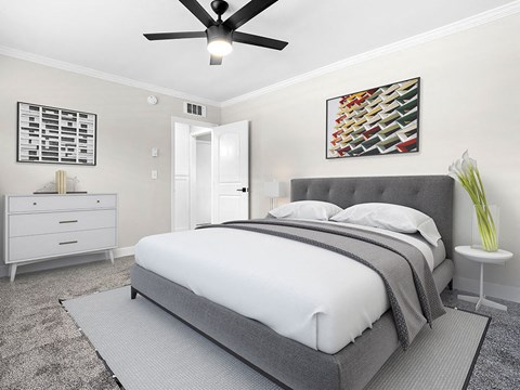 Carpeted bedroom with ceiling fan.