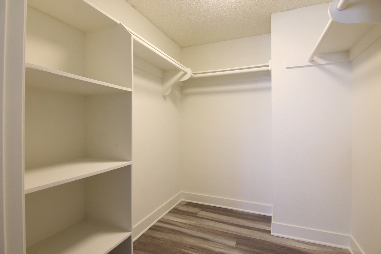 Walk in closet with ample storage, shelves, and hanging rods.