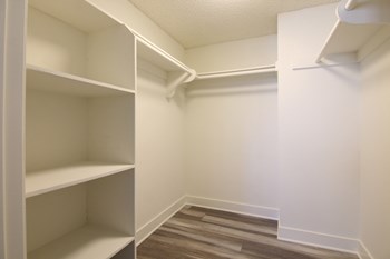Walk in closet with ample storage, shelves, and hanging rods. - Photo Gallery 13