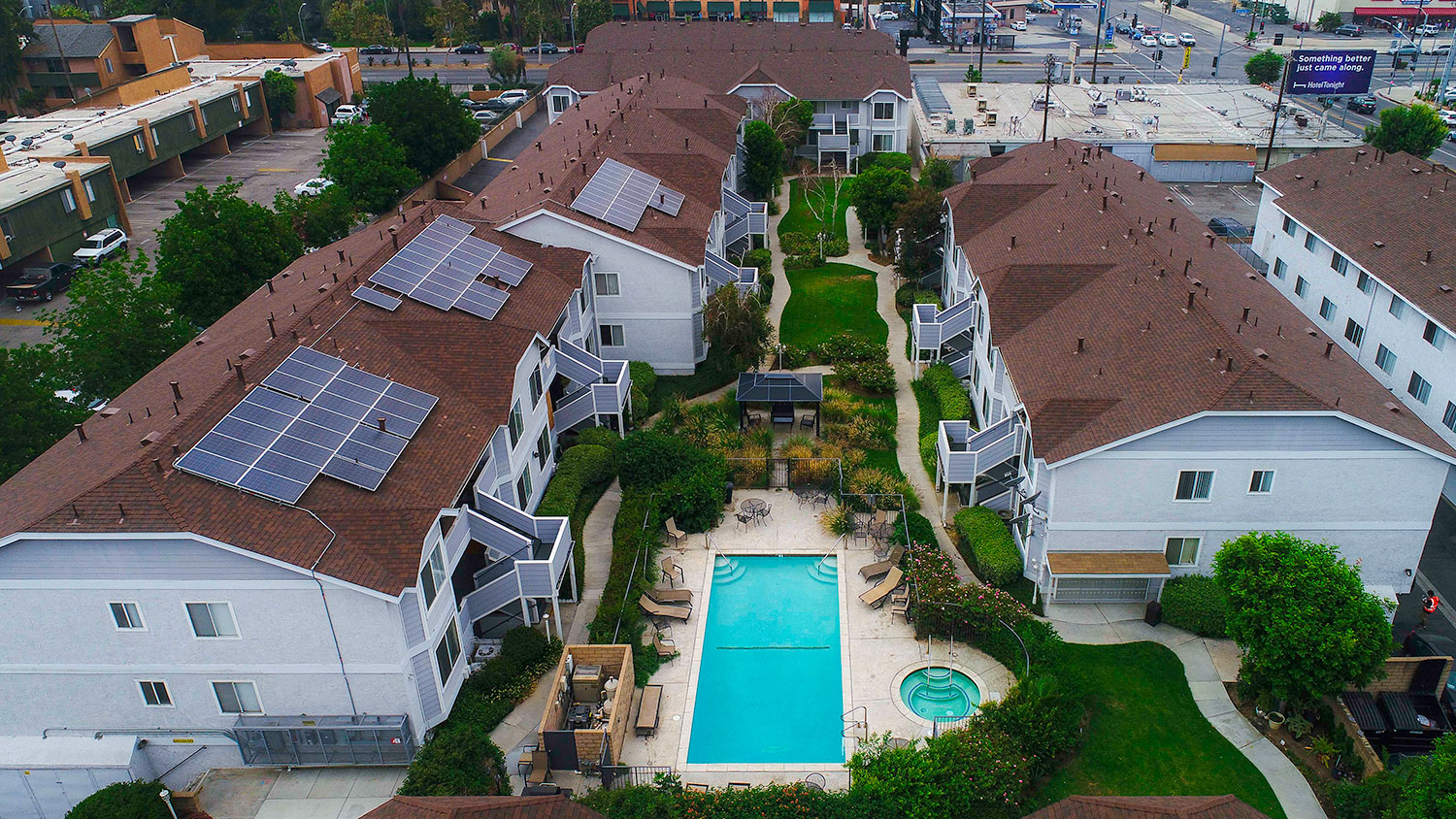 Aerial view of the courtyard, pool, jacuzzi, and solar panels.