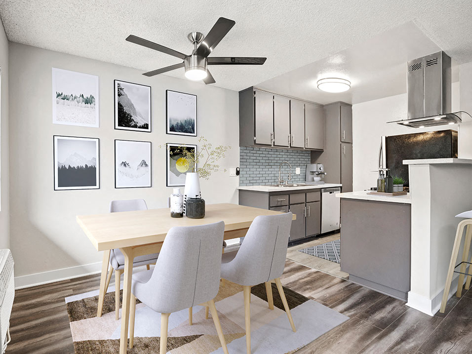 Hardwood floored dining room with ceiling fan and view of kitchen.