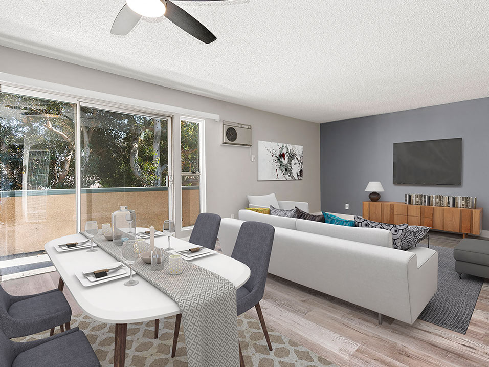 Hardwood floored dining room with ceiling fan and view of living room and private balcony.