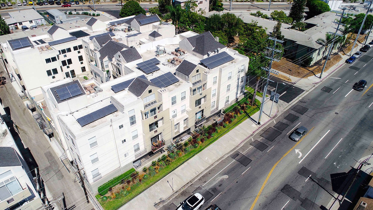 Aerial drone image off Palms Blvd showing solar panels and white roof.