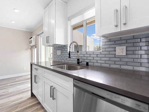 a white kitchen with a sink and a window