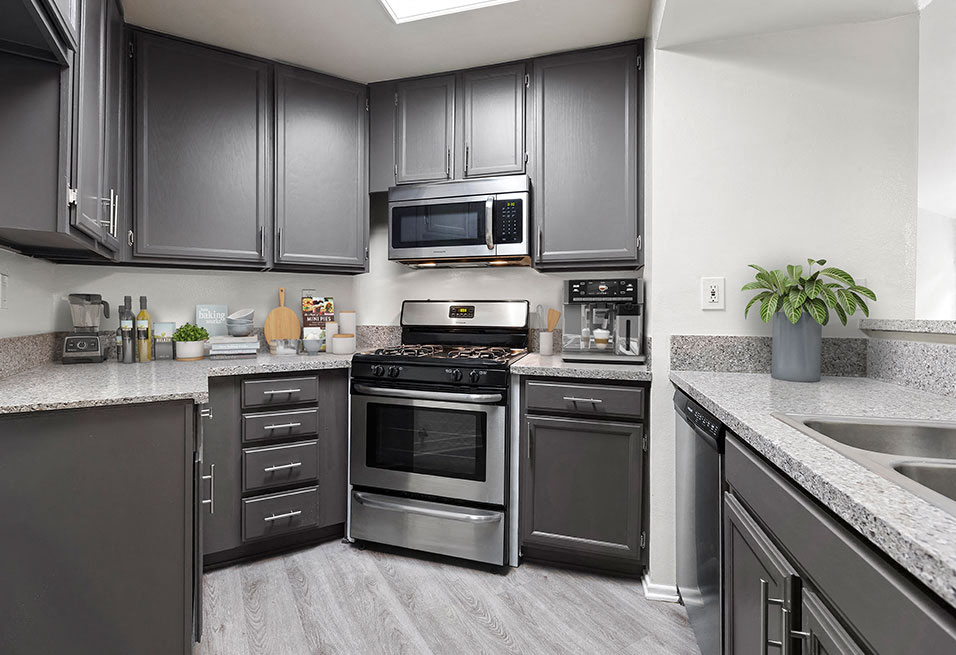 Stone tiled kitchen with stainless steel oven, microwave, and fixtures.