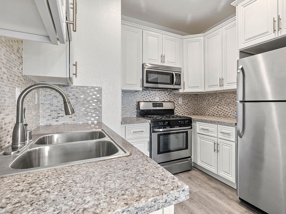 Kitchen with stainless steel fridge, oven, and microwave.