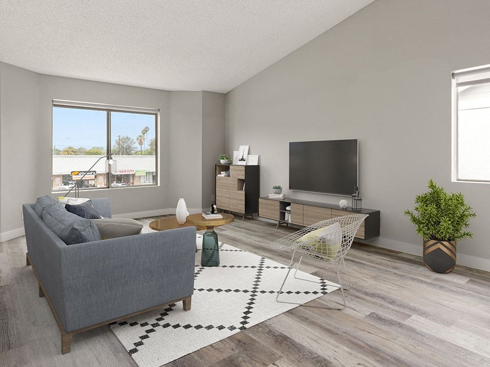 Hardwood floored living room with large windows.