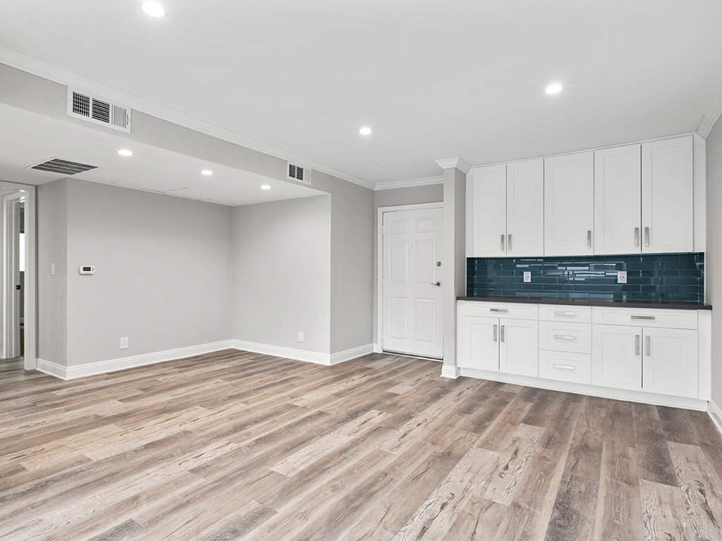 Hardwood floored living room with additional storage and countertop.