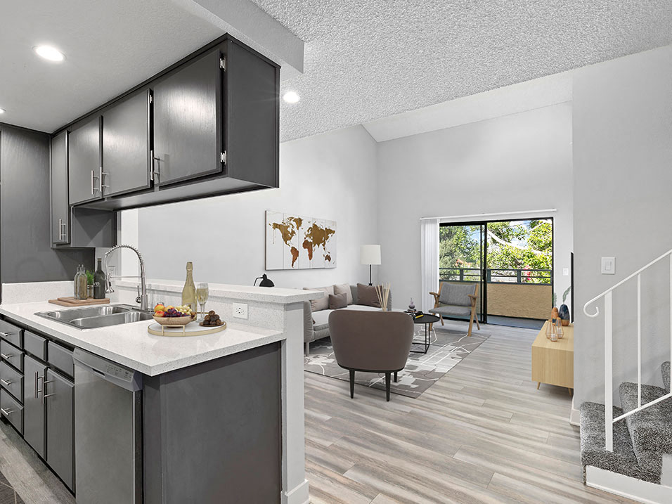 Spacious and open kitchen area with view of living room and balcony.