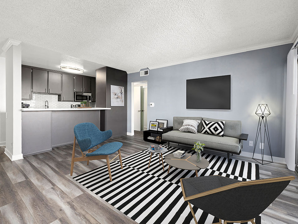 a living room with a striped rug and a kitchen