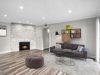 Living room with decorative stone wall, fireplace, and hardwood floors.