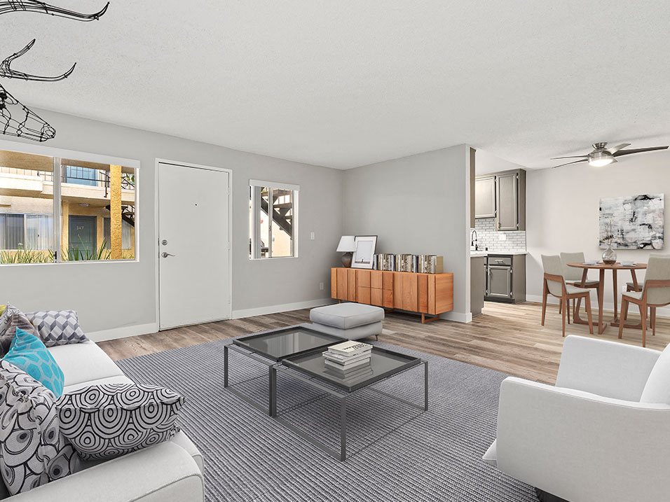 Living room with hardwood floor and view of kitchen and dining area.