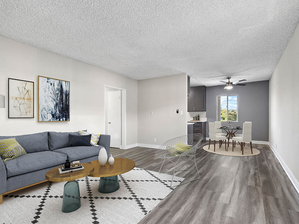 Spacious hardwood floor living room with view of dining area.