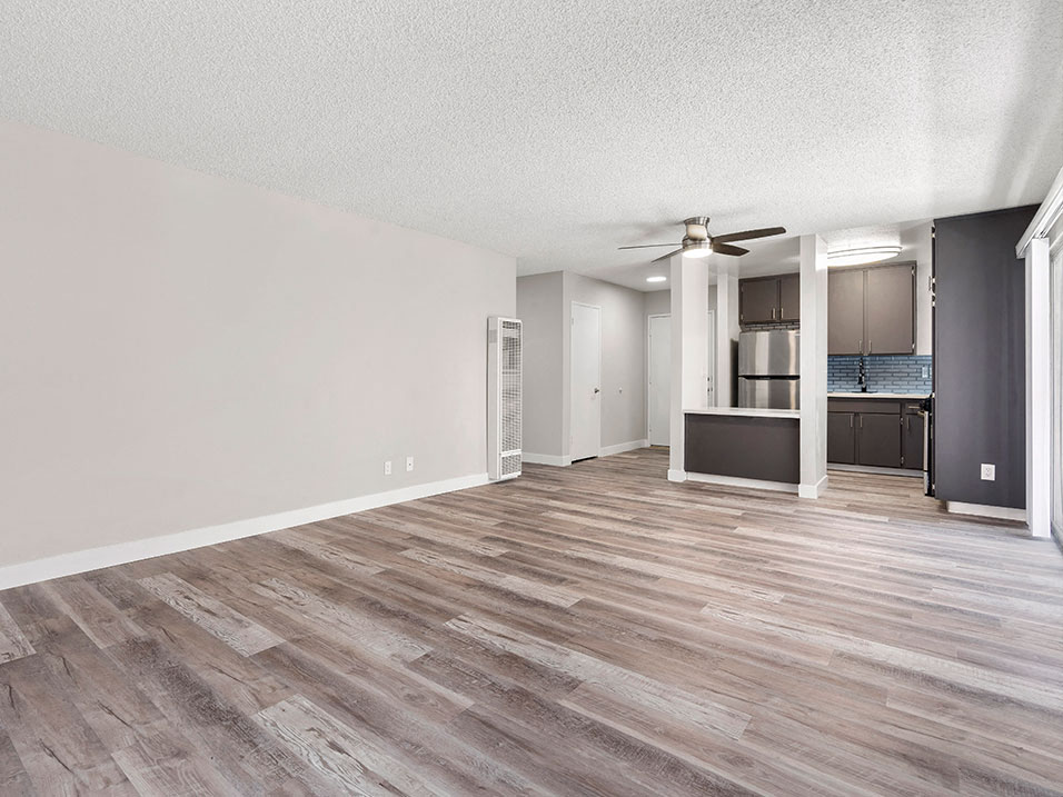 Hardwood floored living room with view of dining area and kitchen.
