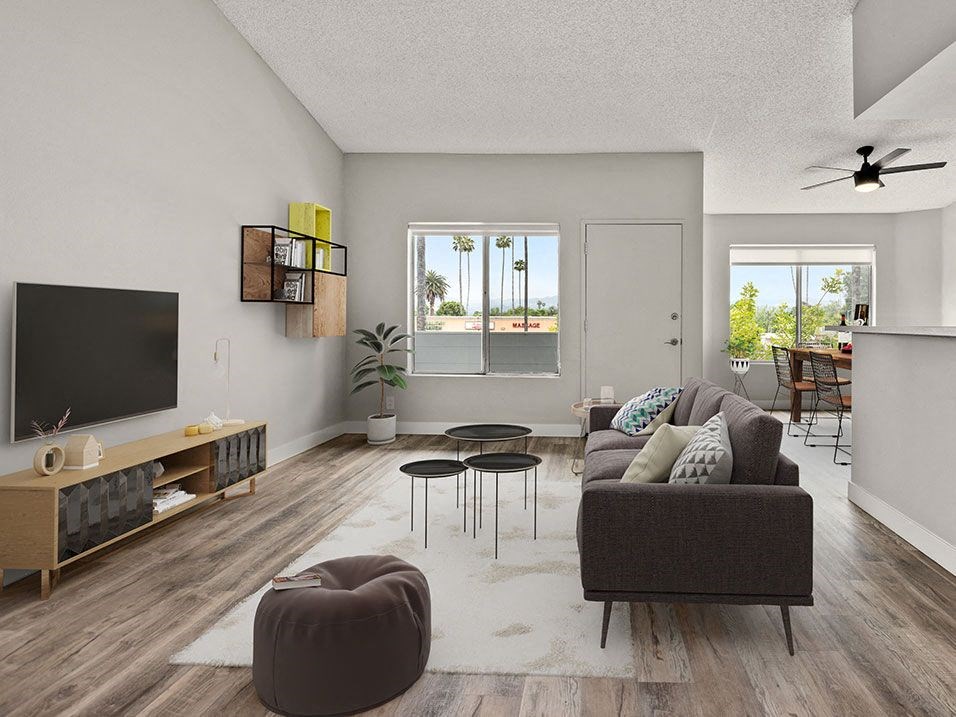 Hardwood floored living room with large windows and view of dining room.