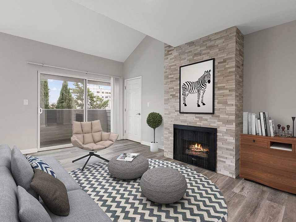 Living room with hardwood floors and stone wall accented fireplace.