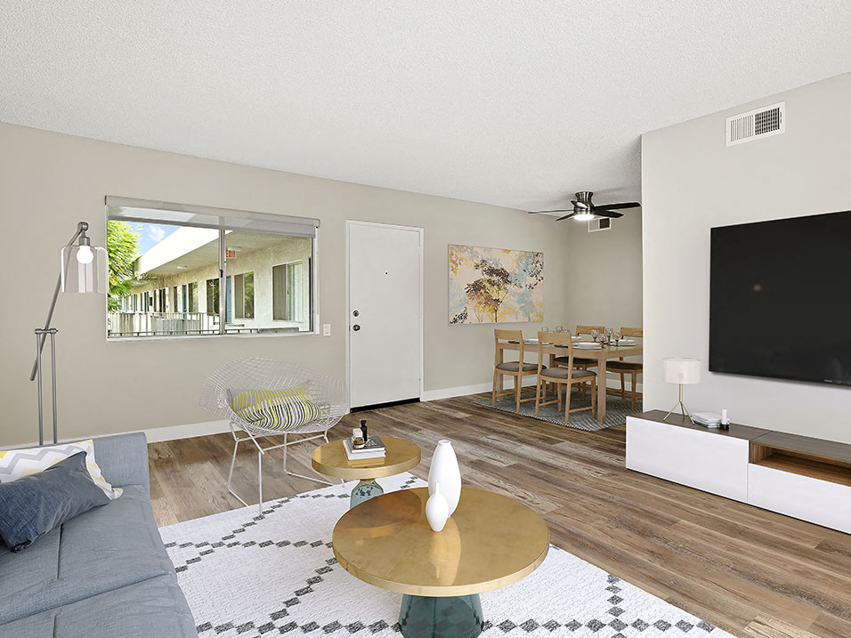 Hardwood floored living room with view of courtyard and dining room.
