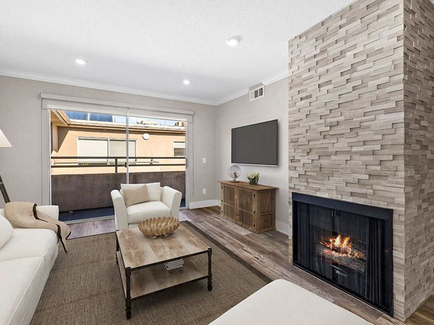 Living room with stone accented fireplace and balcony access. - Photo Gallery 1