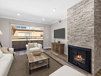 Living room with stone accented fireplace and mounted television.