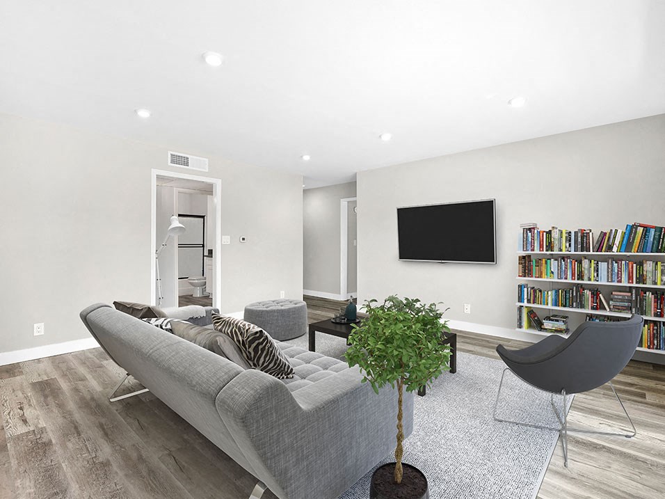 Large hardwood floored living rooms with can lights