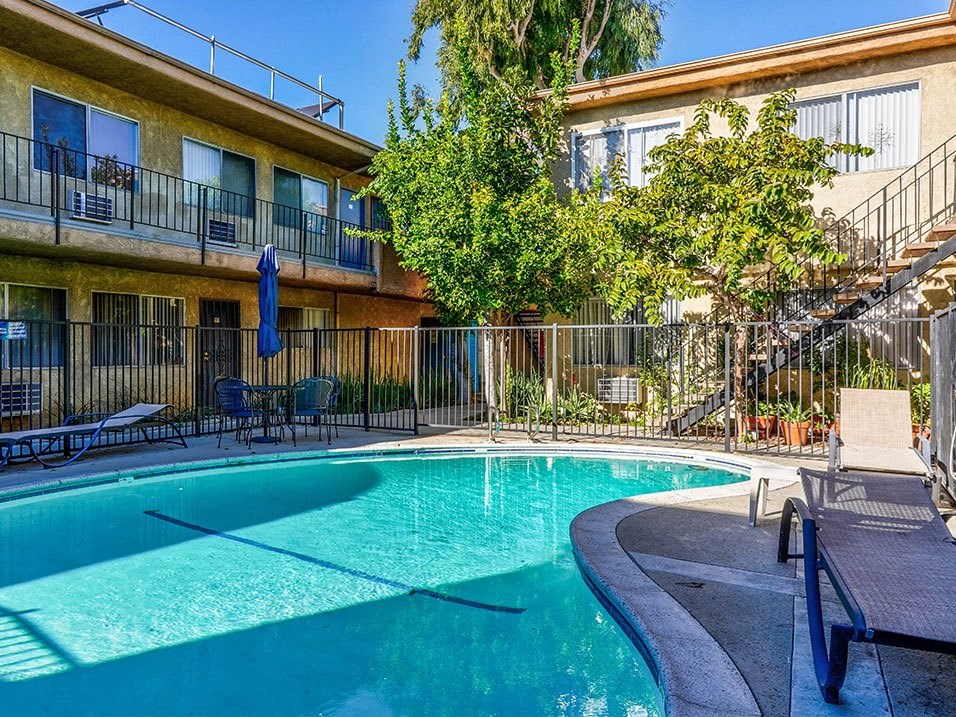 View of gated community pool with lounging space.
