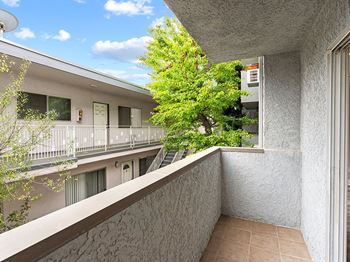A balcony with a tree in the middle of it.