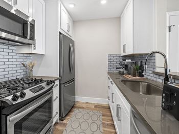 A modern kitchen with a stove, refrigerator, and microwave.