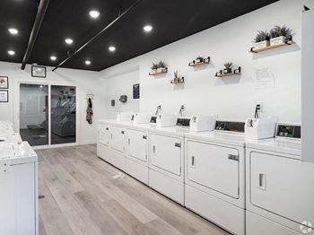 A laundromat with a row of washers and dryers.
