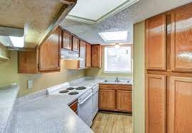 a kitchen with wooden cabinets and a white counter top