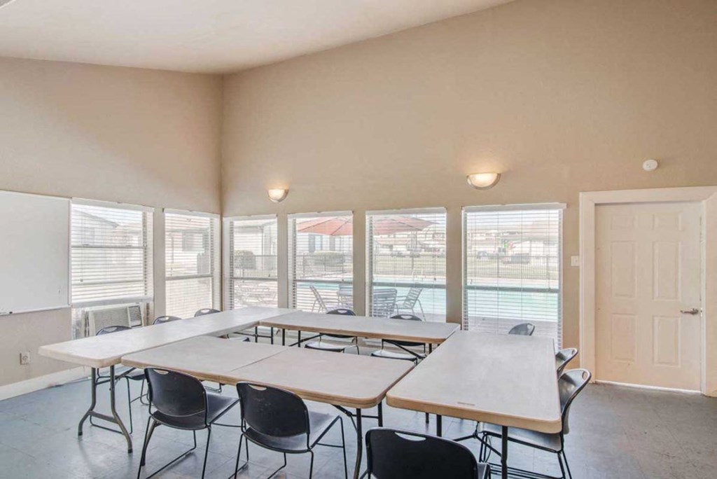 a conference room with tables and chairs and windows