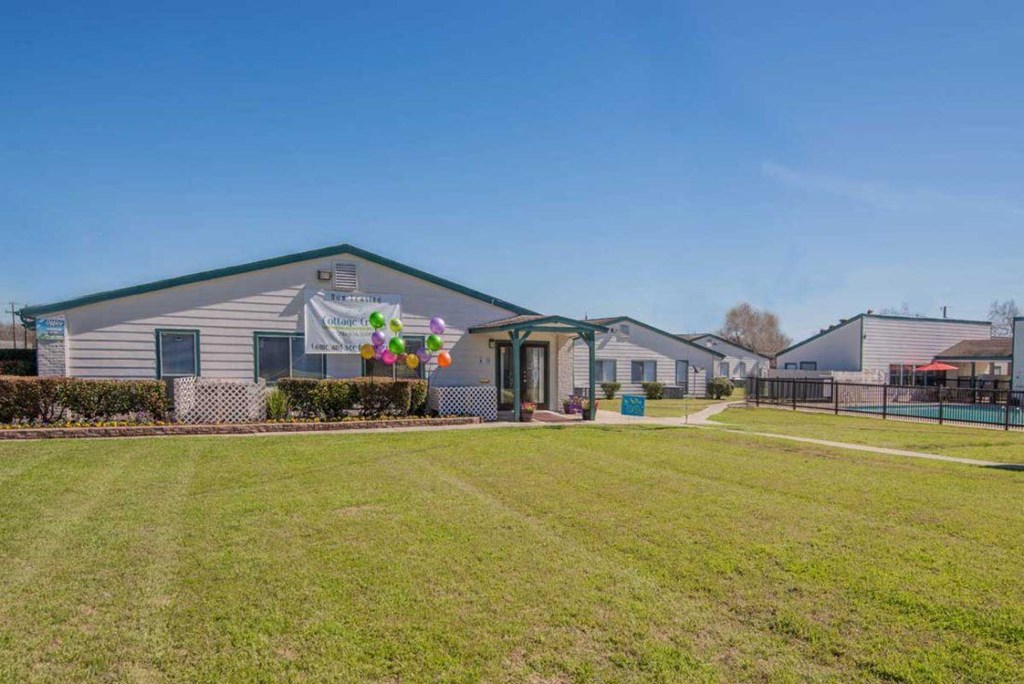 a house with a yard and balloons in front of it