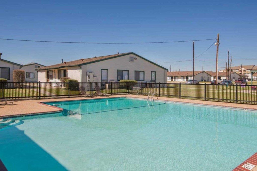 a swimming pool with a house in the background